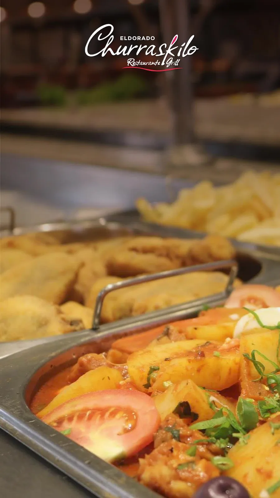 Travessa de cozido com batatas, tomate e azeitonas no buffet quente